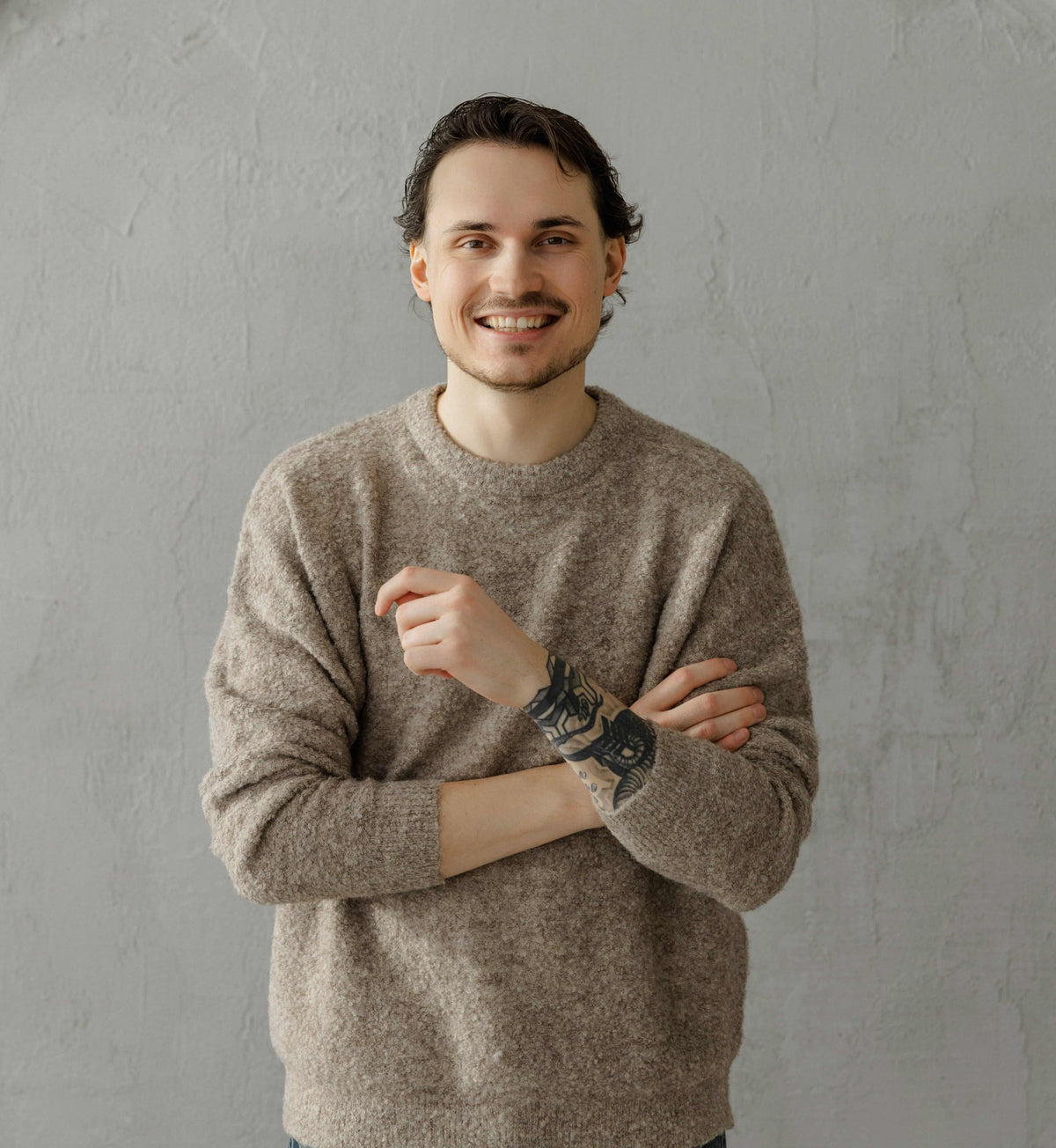 Sanvee founder Kristupas  in neutral sweater standing against minimalist background